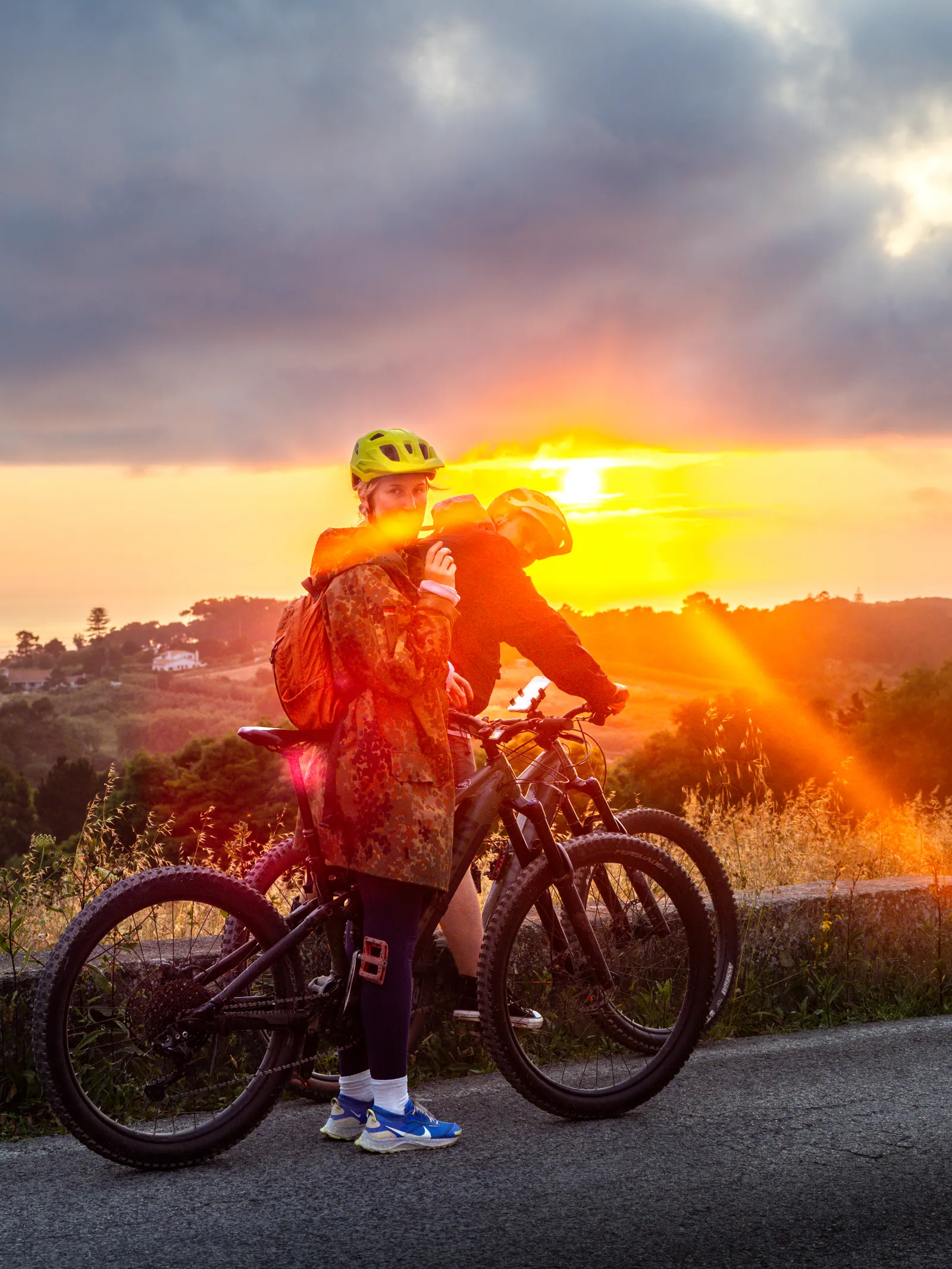 A rider on an eMTB silhouetted against the setting sun on the Sintra coast